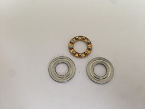 Washer and axial bearing for piston heads or spring guide